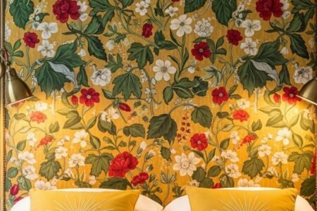 Tete de lit vintage recouverte d un tissu jaune a motifs de fleurs rouges