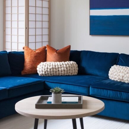 Canape d angle en velours bleu avec coussins orange et paravent japonais