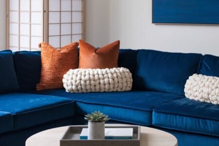 Canape d angle en velours bleu avec coussins orange et paravent japonais
