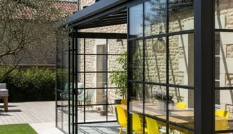 Véranda de style atelier avec structure noire et chaises jaunes