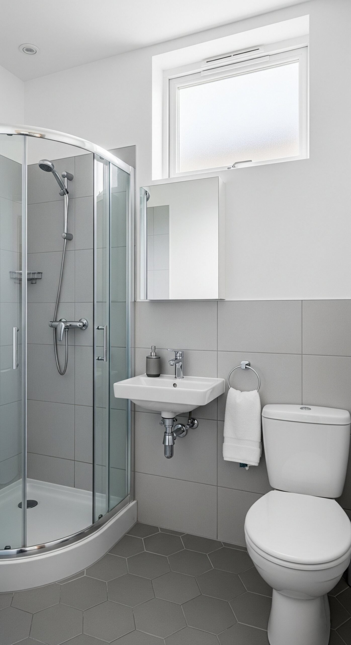Petite salle de bain grise avec douche d angle et carrelage hexagonal