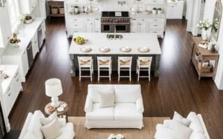 Vaste espace de vie blanc avec cuisine symétrique et parquet foncé