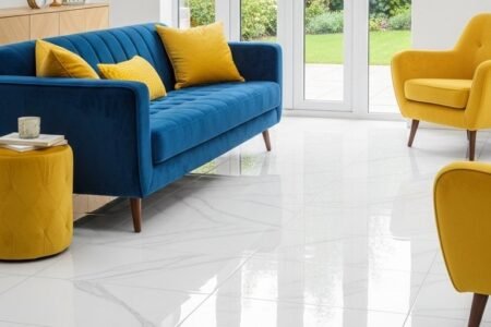 Carrelage blanc brillant effet marbre dans un salon avec canapé bleu et fauteuils jaunes