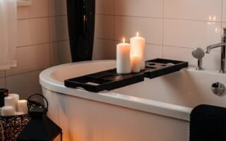Baignoire blanche avec plateau noir et lanternes noires au sol