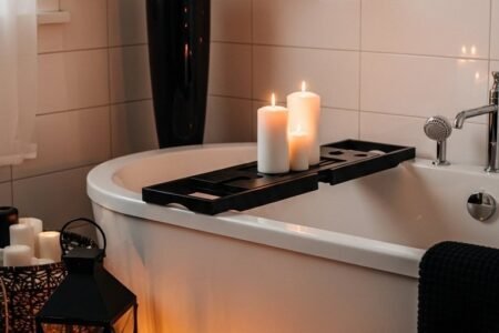 Baignoire blanche avec plateau noir et lanternes noires au sol