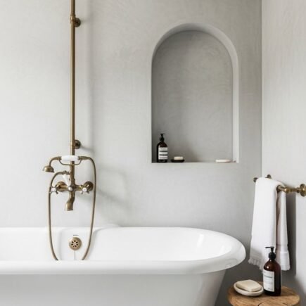 Baignoire retro sur pieds avec murs en beton cire gris et niche voutee