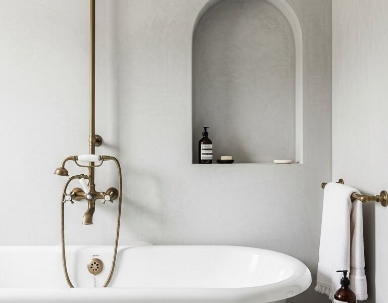 Baignoire retro sur pieds avec murs en beton cire gris et niche voutee