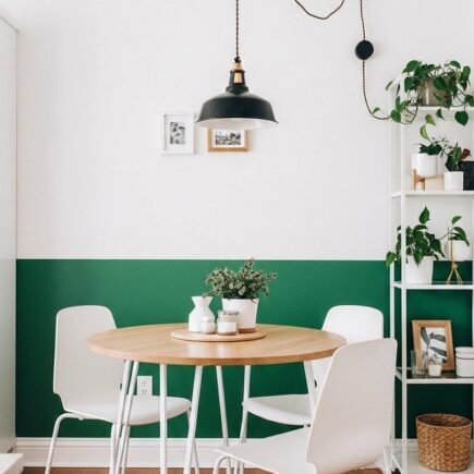 Petit coin repas avec mur peint en vert a mi hauteur et table ronde en bois
