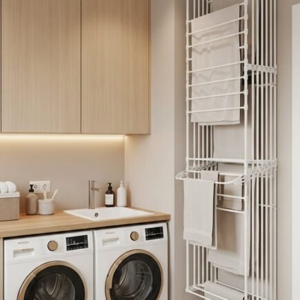 Buanderie avec sechoir mural vertical et machines blanches et dorees